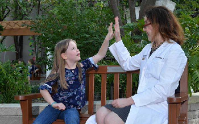 Following care for moyamoya, Stacey high fives Dr. Guilliams