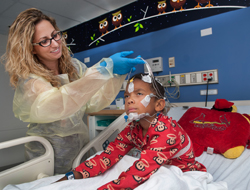 Ashley Greulich, RT, a registered polysomnographic technician, removes electrodes from the face and scalp of patient Zachary Volz, 7. The painless, noninvasive sleep study measures the quality of the patient's sleep and is used to diagnose and treat many sleep disorders.