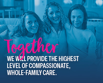 Maddy, a St. Louis Children’s patient, and her twin sister with arms around their mom