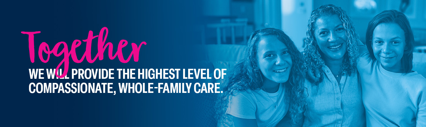 Maddy, a St. Louis Children’s patient, and her twin sister with arms around their mom