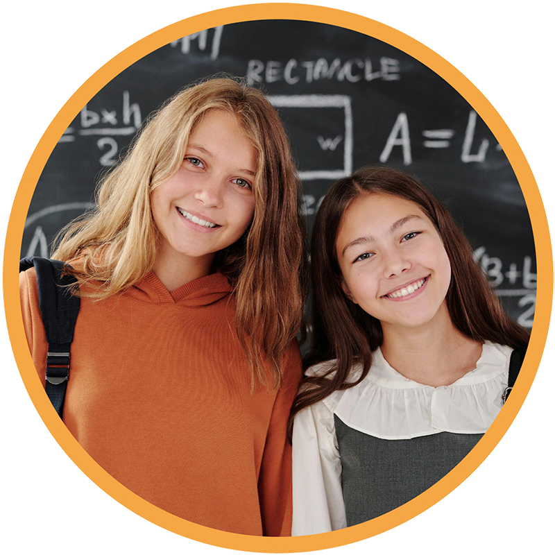 Two girls standing in front of of a chalkboard