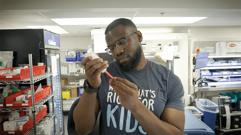 A man holding a bottling and syringe