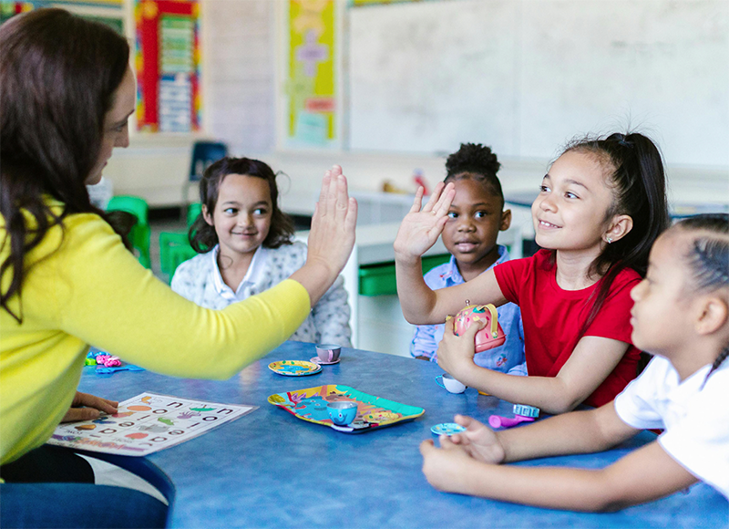 Teacher sitting at a table with four students