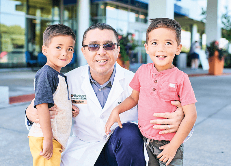 Photo of a doctor with two young boy patients