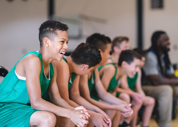 Athlete kids sitting on a bench and laughing