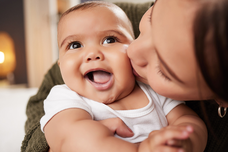 Mom hugging and kissing a baby