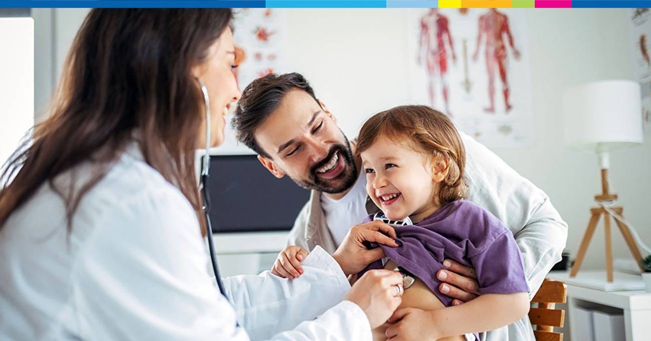 Child being examined by a doctor while the father is holding the child