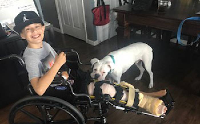 Ashton is comforted by his dog following surgery to repair injuries sustained in a boating accident.