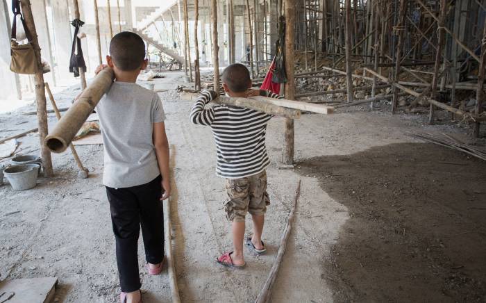 Two kids walking in a construction site