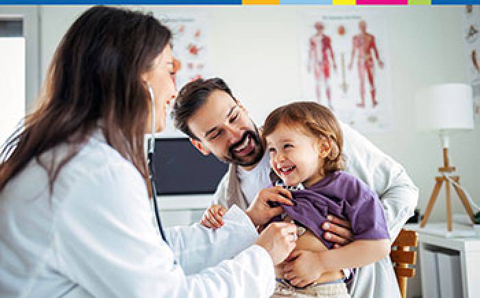 Child being examined by a doctor while the father is holding the child