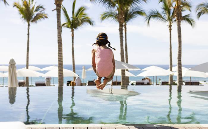 Young girl jumping into a pool